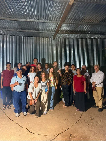 Mission-trip participants gathered for a group photo beneath a metal roof