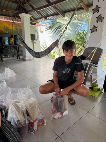 A young volunteer packing bags of food supplies