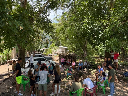 A community gathering in the shade of trees